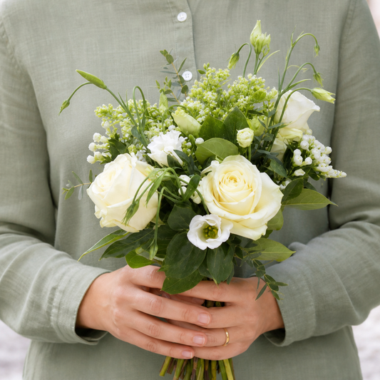 Person holding the DESIRE bouquet outdoors, torso only without face