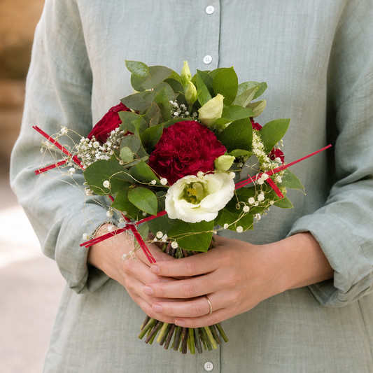Person holding the DIVINE bouquet outdoors, torso only without face