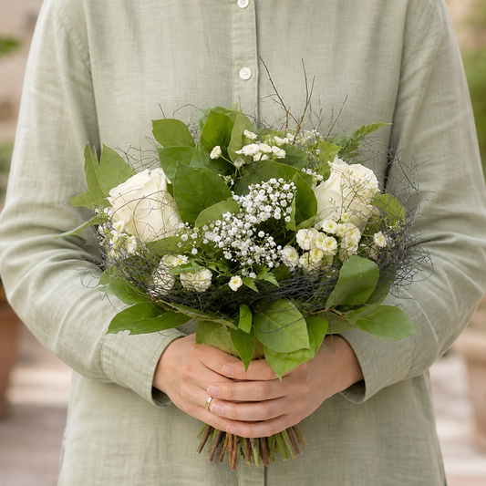 Person holding the EMBRACED bouquet outdoors, torso only without face