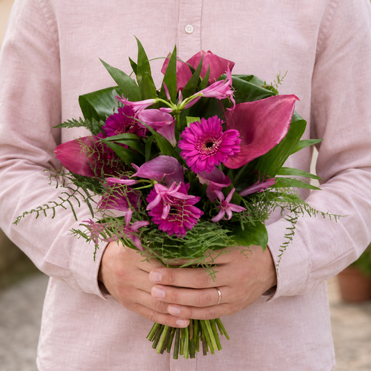 Person holding the EXCEPTION bouquet outdoors, torso only without face