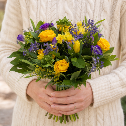 Person holding the HOLIDAY bouquet outdoors, torso only without face