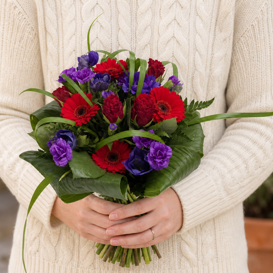 Person holding the PARTY bouquet outdoors, torso only without face