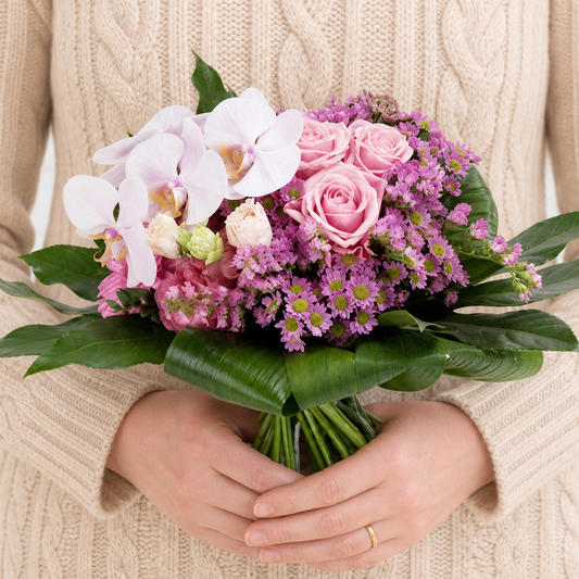 Person holding the TENDER bouquet outdoors, torso only without face