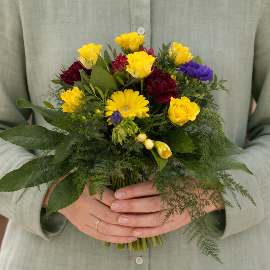 Person holding the VIVACIOUS bouquet outdoors, torso only without face
